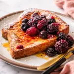 Delicious air fryer French toast served with maple syrup and berries.