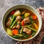 A bowl of Thai Pork Rib Soup with fresh vegetables and herbs