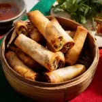 Plate of ultimate crispy veggie spring rolls with dipping sauce.